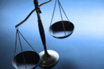 A balance scale against a blue background, symbolizing justice and fairness.