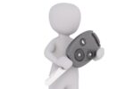 A 3D-rendered figure holding an oversized car key with a remote control attached, symbolizing car ownership or automotive concepts.