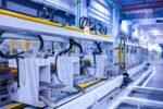 A manufacturing assembly line in a factory setting, showcasing robotic machinery and equipment used for automation and production.